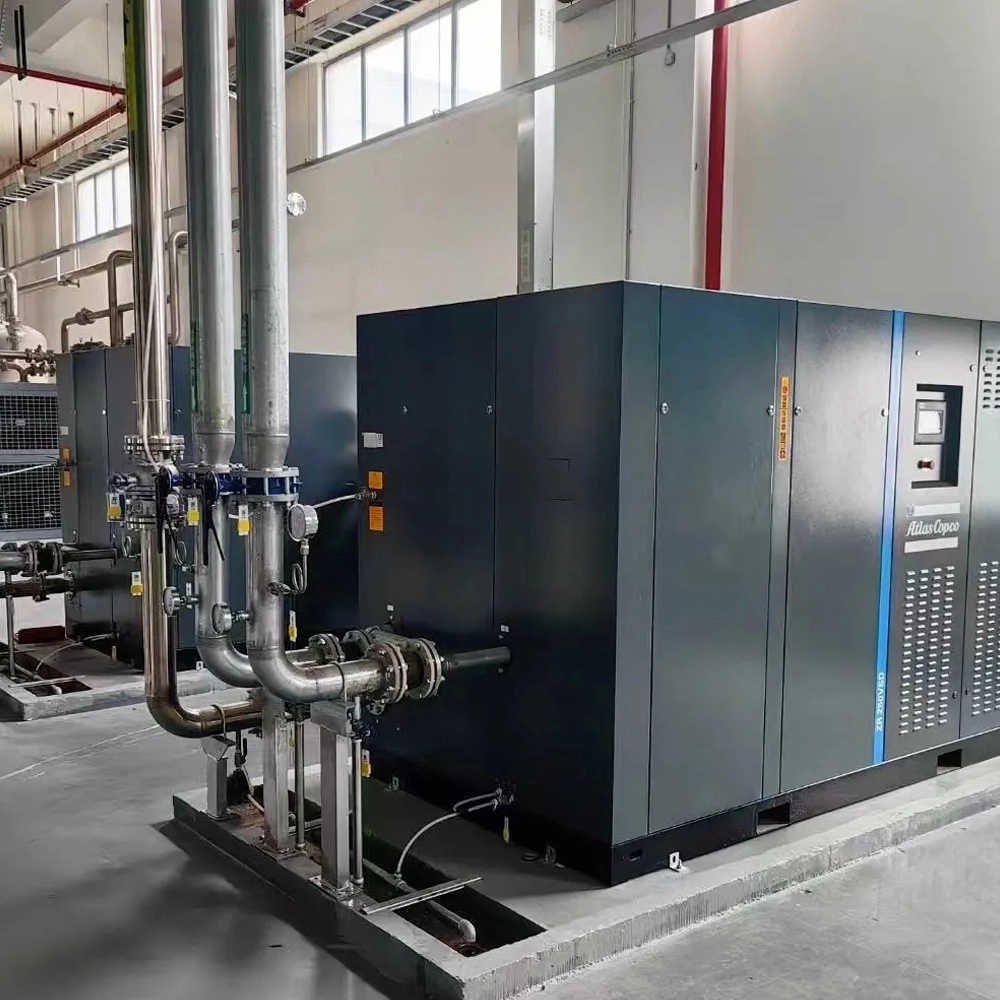 A professional industrial compressor station featuring Atlas Copco oil-free compressors integrated with process piping and 3-year warranty flexible rubber expansion joints