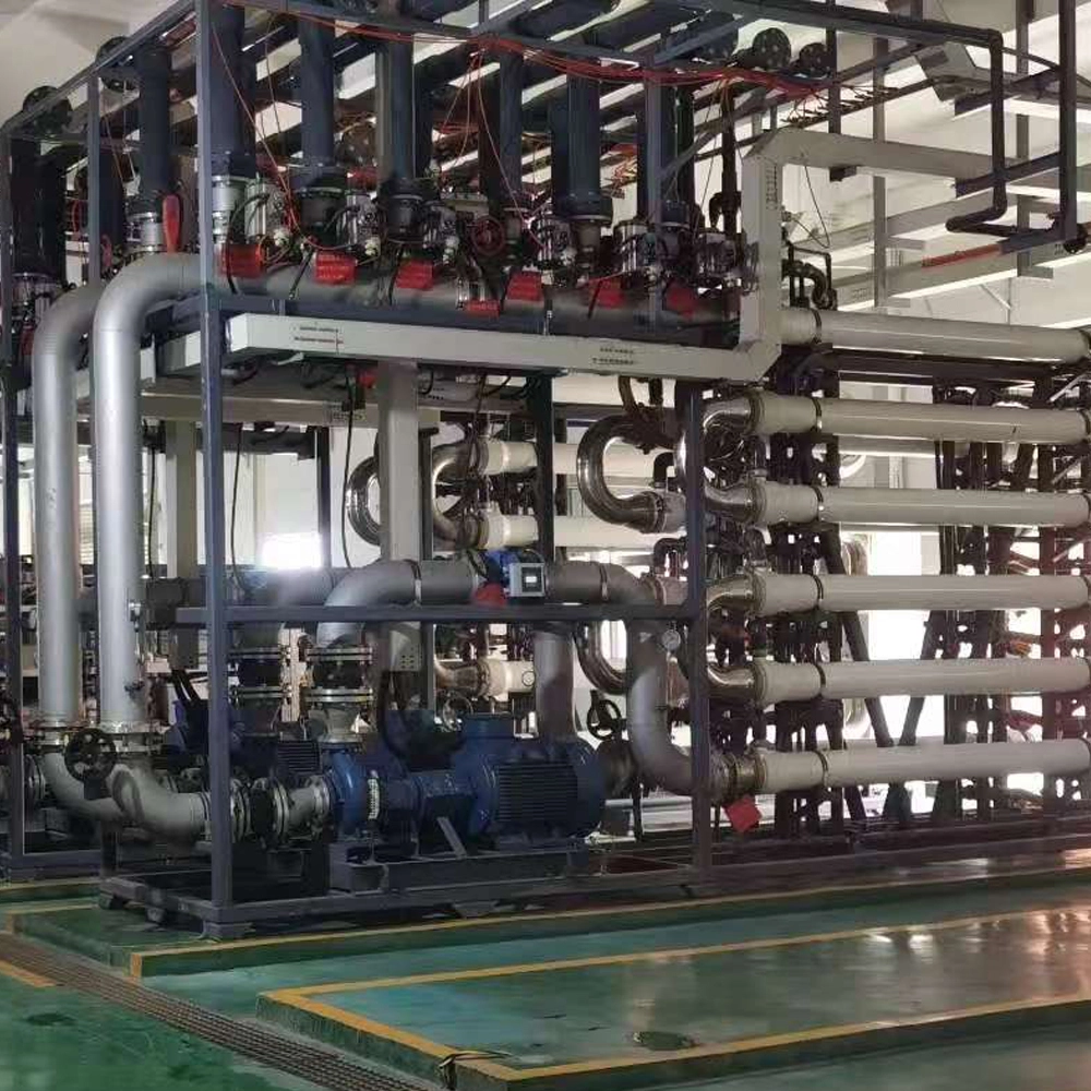 A heavy-duty industrial wastewater treatment plant piping skid featuring high-pressure feed pumps, filtration manifolds, and chemical-resistant rubber expansion joints